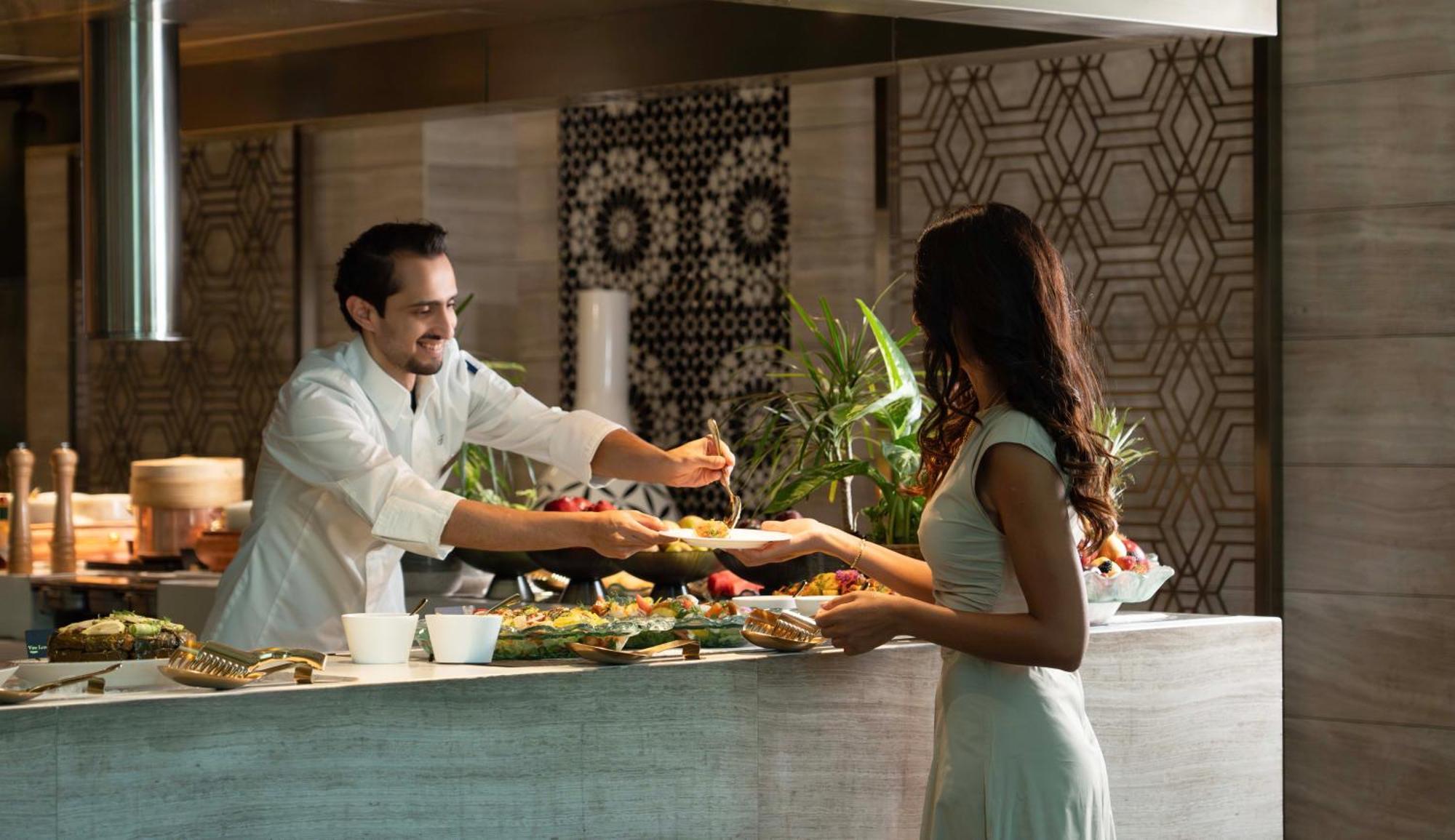 Fairmont Riyad Extérieur photo A chef serving a guest at the buffet